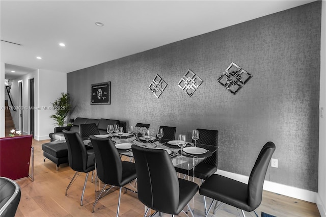 dining area with recessed lighting, an accent wall, baseboards, and wood finished floors