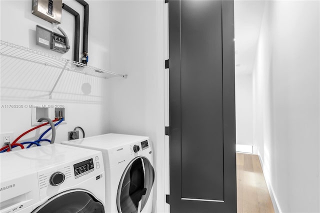 clothes washing area with laundry area, independent washer and dryer, light wood-type flooring, and baseboards