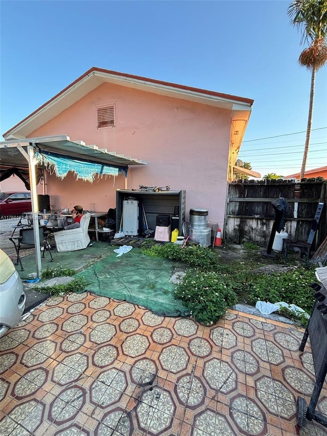 back of property featuring a patio area, fence, and stucco siding