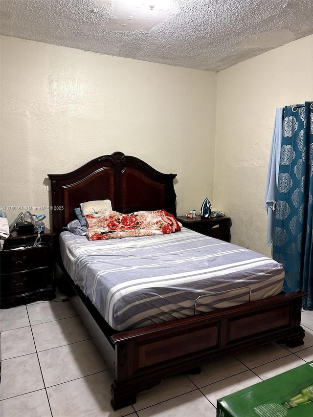 bedroom featuring light tile patterned flooring and a textured ceiling