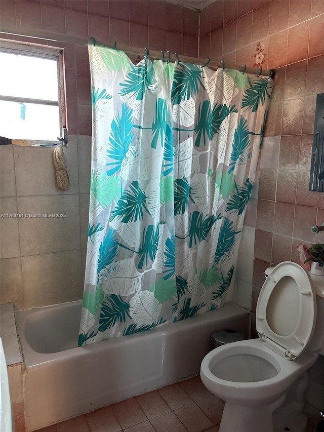 full bathroom with tile patterned floors, shower / tub combo with curtain, tile walls, and toilet