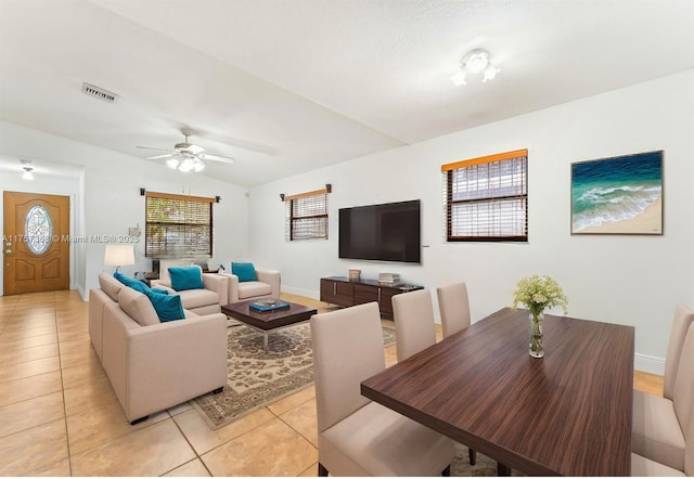 living area with vaulted ceiling, light tile patterned flooring, baseboards, and visible vents