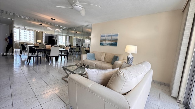 living room featuring light tile patterned floors, a textured ceiling, and a ceiling fan