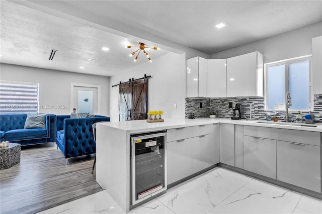 231 NW 44th St, Miami, FL 33127 - kitchen with beverage cooler, a sink, modern cabinets, a barn door, and open floor plan
