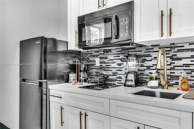 231 NW 44th St, Miami, FL 33127 - kitchen with black appliances, decorative backsplash, a sink, and white cabinetry