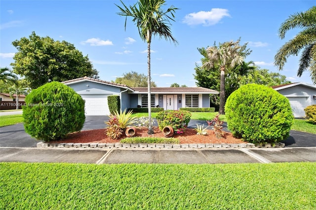 ranch-style home with stucco siding, driveway, a tile roof, and a garage