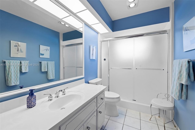 bathroom featuring tile patterned flooring, a shower stall, toilet, and vanity