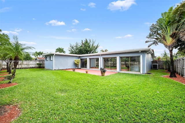 rear view of house with a patio area, a lawn, cooling unit, and a fenced backyard