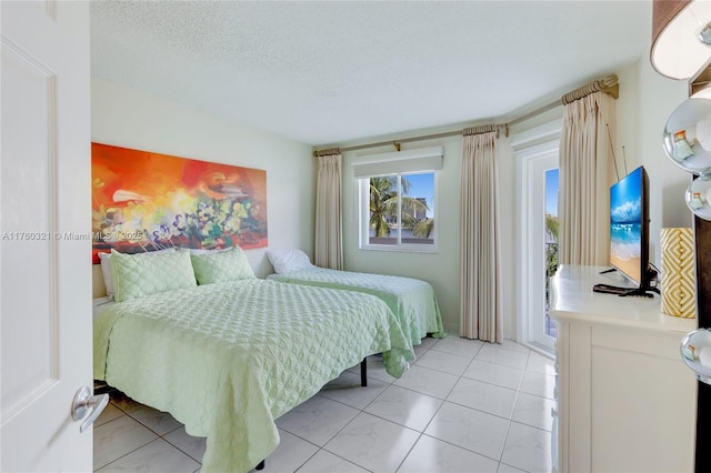 bedroom with light tile patterned floors, a textured ceiling, and access to outside