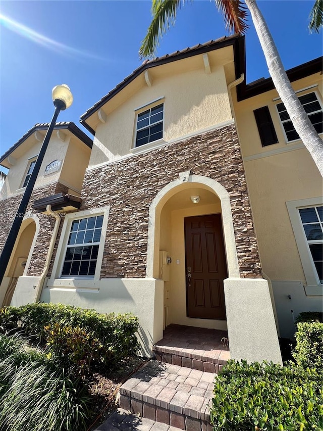 property entrance with stone siding and stucco siding