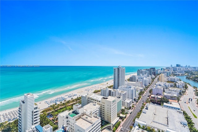 drone / aerial view with a beach view, a view of city, and a water view