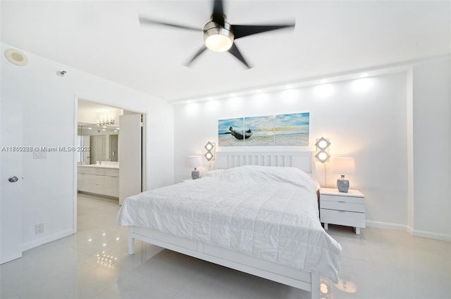 bedroom featuring a ceiling fan, ensuite bathroom, baseboards, and a sink