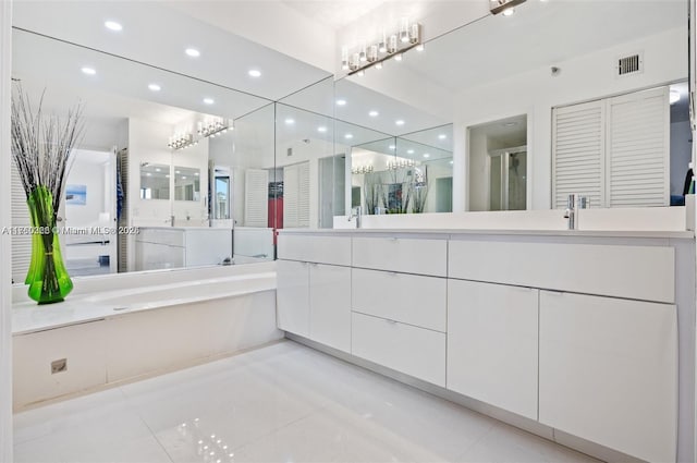 bathroom with visible vents, double vanity, a sink, tile patterned flooring, and a bath