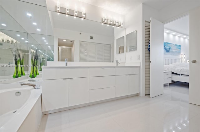 ensuite bathroom with a garden tub, a stall shower, a sink, ensuite bath, and double vanity