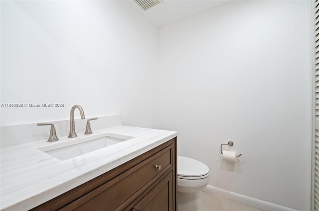 bathroom featuring tile patterned flooring, visible vents, baseboards, toilet, and vanity