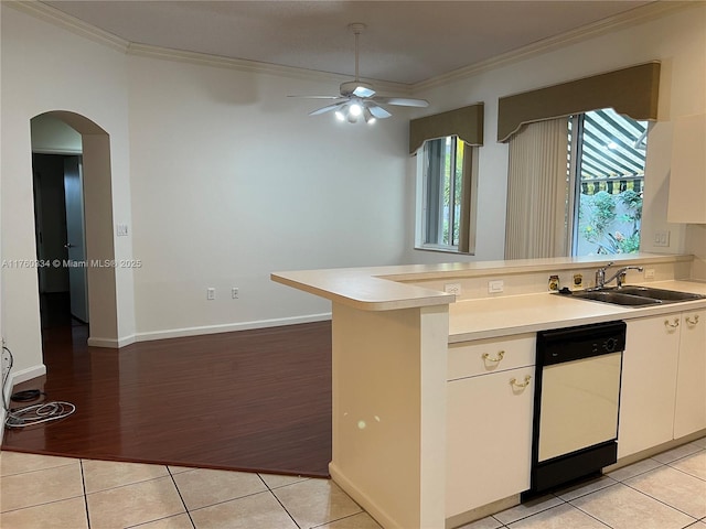 kitchen with light tile patterned floors, ornamental molding, a peninsula, and white dishwasher