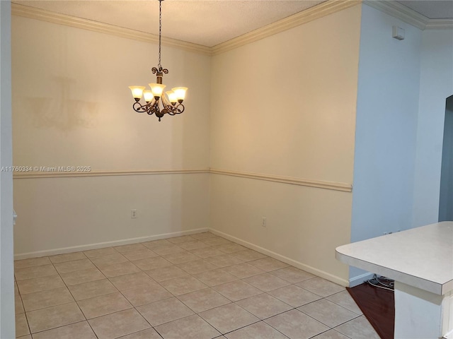 unfurnished dining area featuring a notable chandelier, baseboards, and ornamental molding