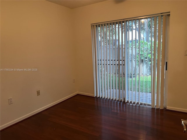 unfurnished room with a wealth of natural light, baseboards, and wood finished floors