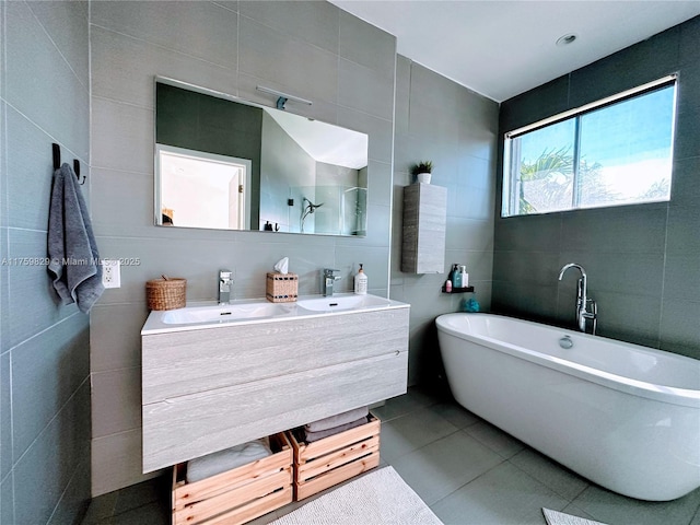 full bathroom featuring tile patterned flooring, double vanity, tile walls, and a sink