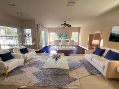 living area with visible vents, wood finished floors, and a ceiling fan