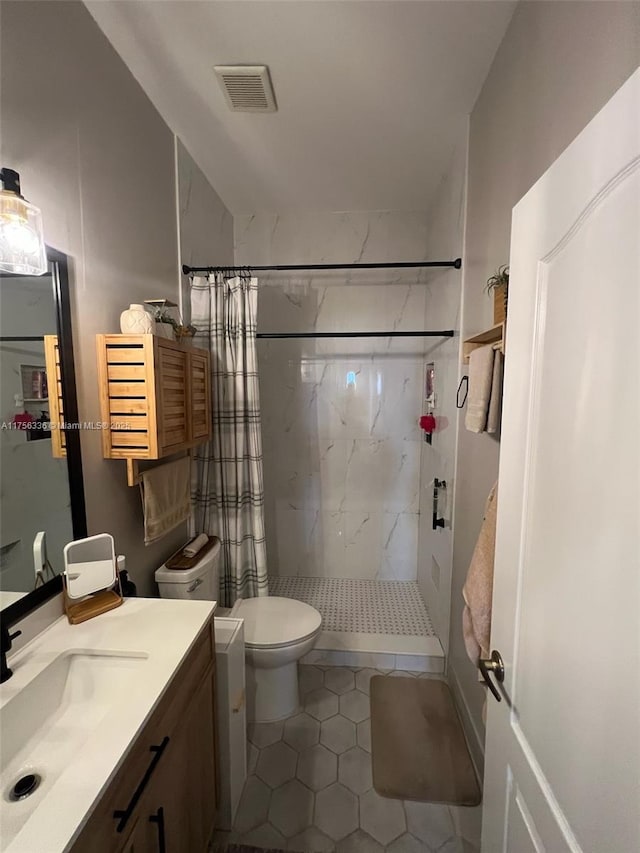 bathroom featuring visible vents, vanity, toilet, and a shower stall