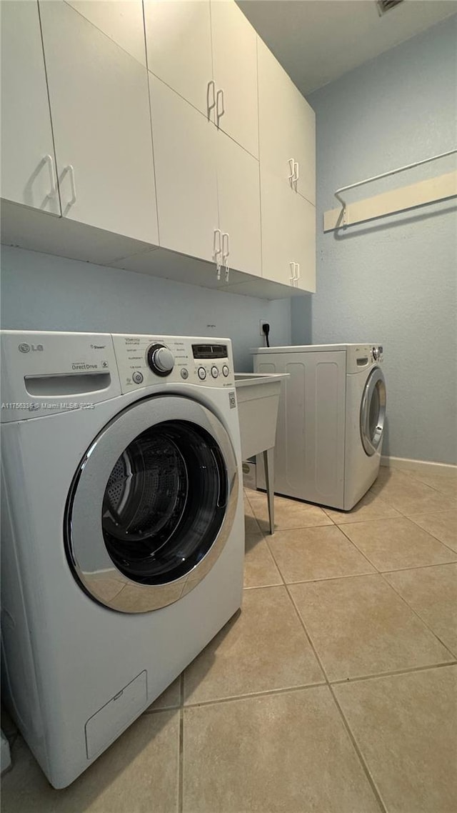 laundry area with cabinet space, light tile patterned floors, washer / dryer, and visible vents