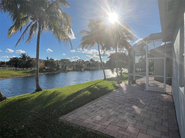 view of patio / terrace featuring glass enclosure and a water view