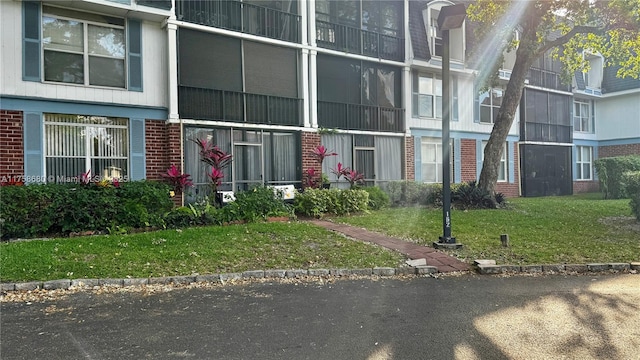 exterior space with brick siding and a lawn