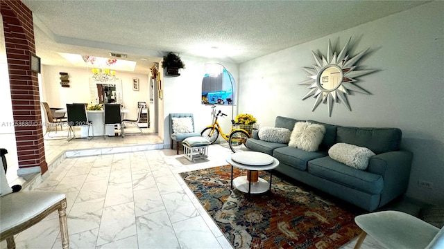 living area with visible vents, marble finish floor, and a textured ceiling