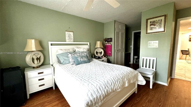 bedroom with ceiling fan, a textured ceiling, baseboards, and wood finished floors