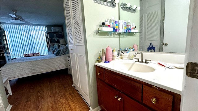 bathroom featuring vanity, wood finished floors, a closet, and a ceiling fan