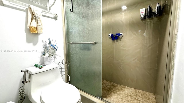 bathroom with a shower stall and toilet