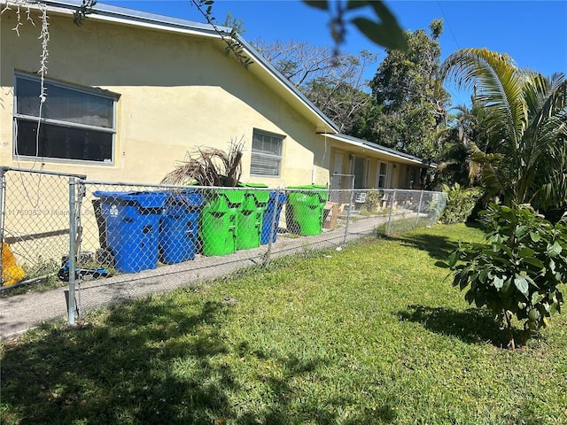 view of home's exterior featuring a yard, fence, and stucco siding