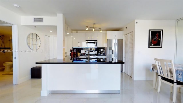 kitchen with baseboards, visible vents, white cabinets, appliances with stainless steel finishes, and dark countertops