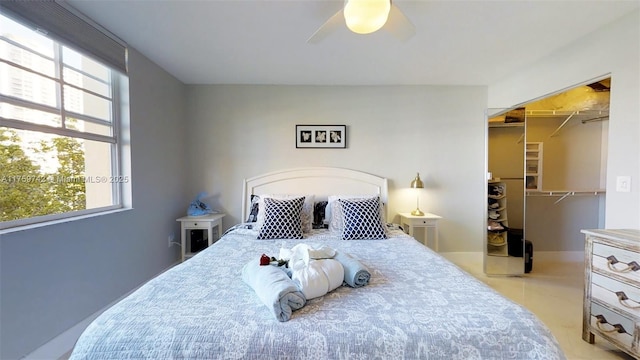 bedroom with ceiling fan, a closet, multiple windows, and a walk in closet