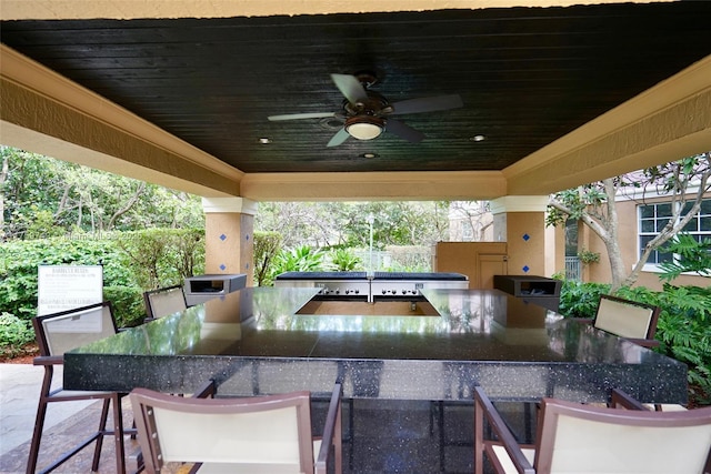 view of patio / terrace featuring outdoor dining space, exterior kitchen, and a ceiling fan