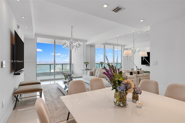 dining area with plenty of natural light, a notable chandelier, visible vents, and expansive windows