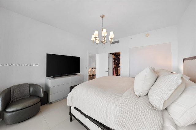 bedroom with visible vents, a walk in closet, and a chandelier