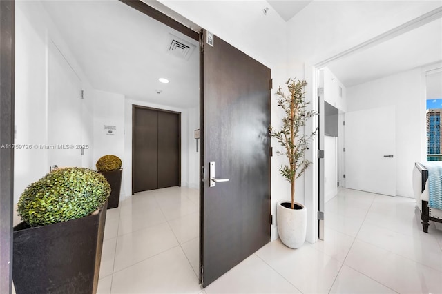 hallway with elevator, visible vents, recessed lighting, and light tile patterned floors