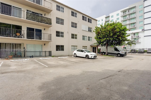 view of property featuring uncovered parking and fence