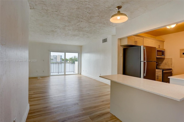 kitchen with visible vents, light countertops, light wood-type flooring, appliances with stainless steel finishes, and a textured ceiling