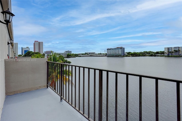 balcony featuring a water view and a city view