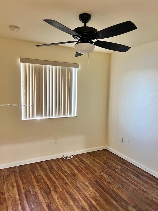 spare room with baseboards and wood finished floors