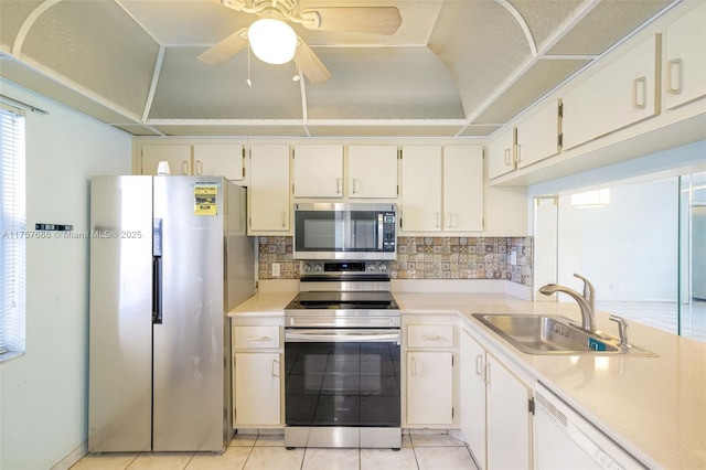 kitchen featuring tasteful backsplash, stainless steel appliances, light countertops, and a sink