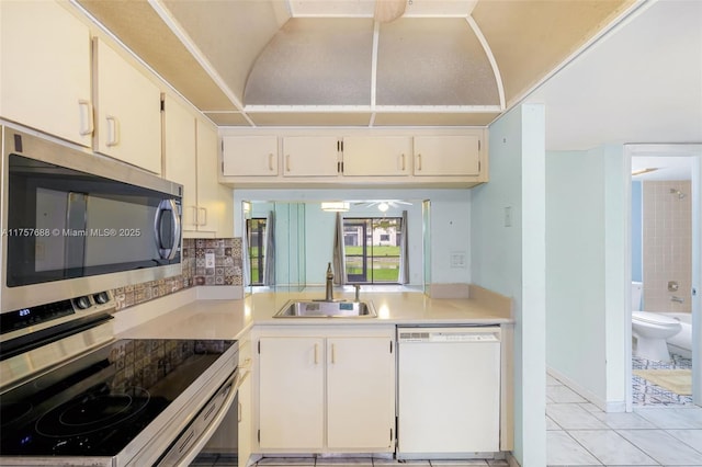 kitchen featuring a sink, tasteful backsplash, appliances with stainless steel finishes, light tile patterned flooring, and light countertops