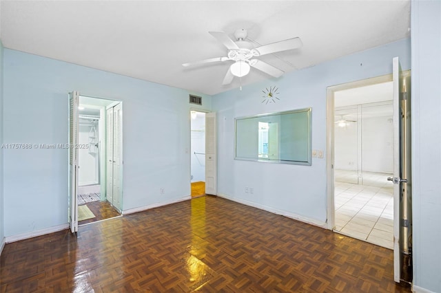 spare room featuring a ceiling fan, visible vents, and baseboards