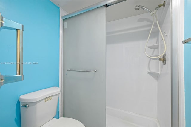 bathroom featuring a shower stall and toilet