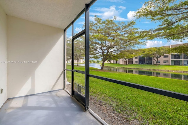 unfurnished sunroom featuring a water view