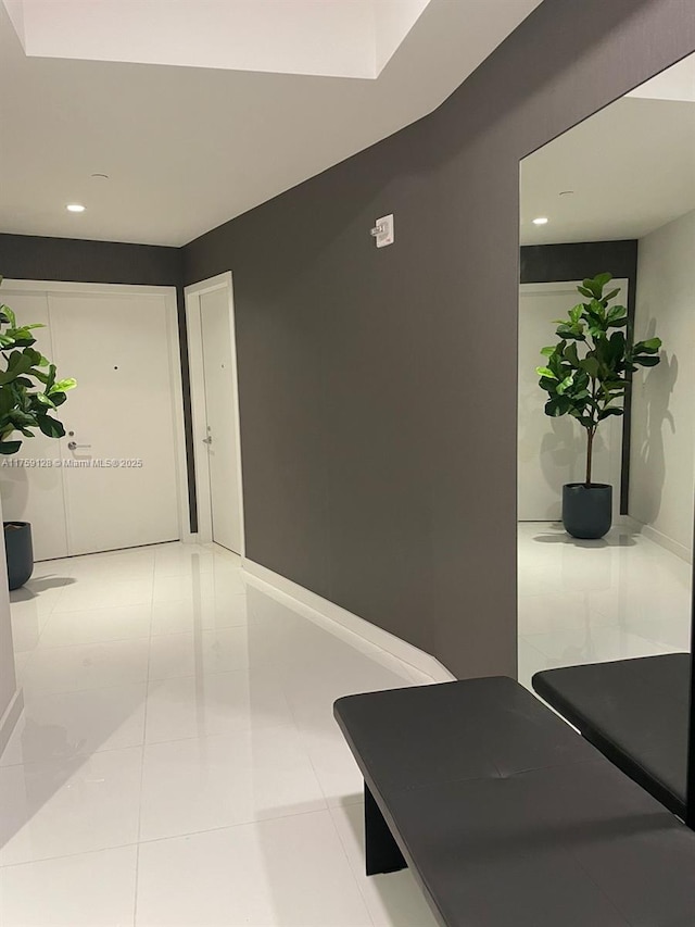 hall featuring light tile patterned flooring, recessed lighting, and baseboards