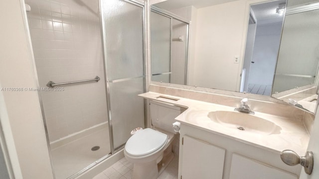 bathroom featuring vanity, tile patterned floors, toilet, and a stall shower